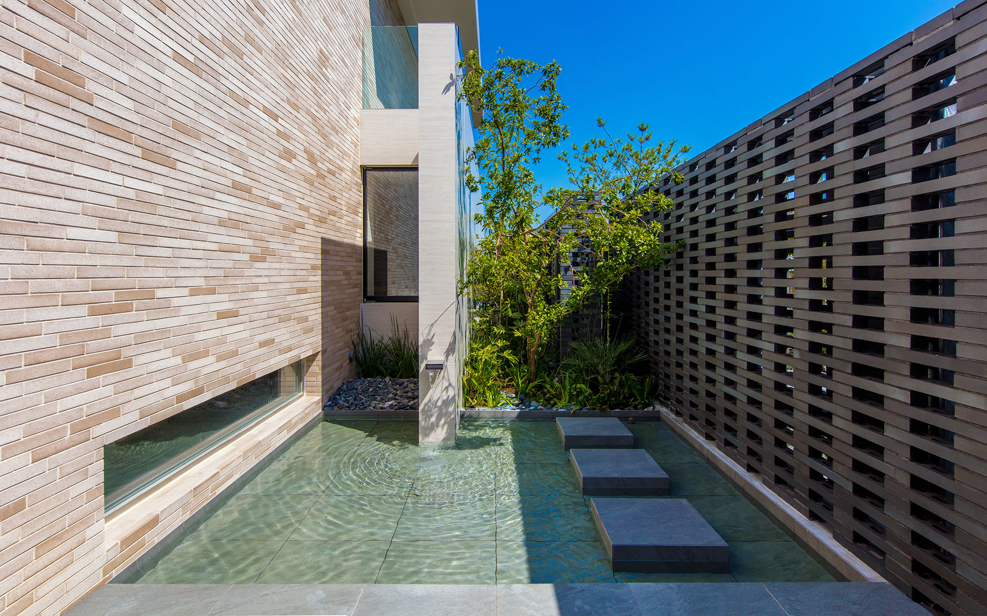 芦屋にある設計事務所設計のRC造高級住宅 水盤のあるアプローチ実例写真